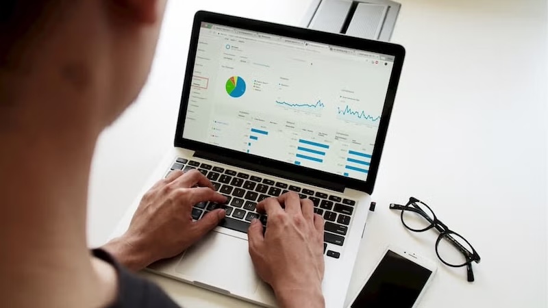 An infographic displayed on laptop with data on the demand for business analytics roles and salaries across Australian states.