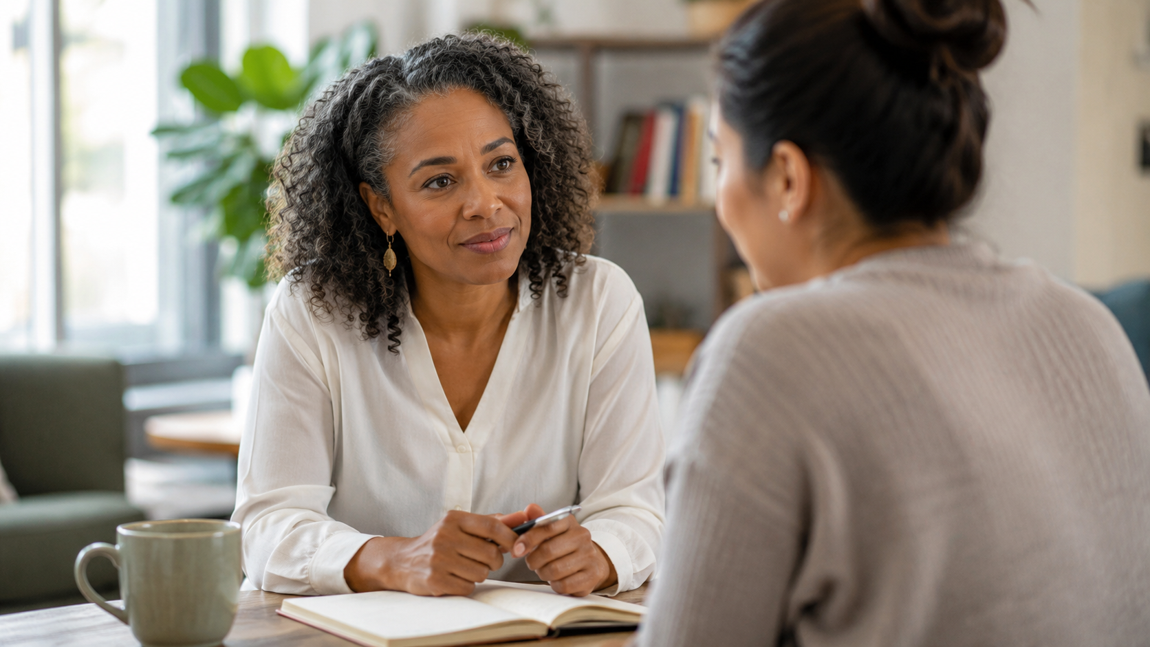 A learning professional sitting one-on-one with a learner or colleague, having a supportive conversation