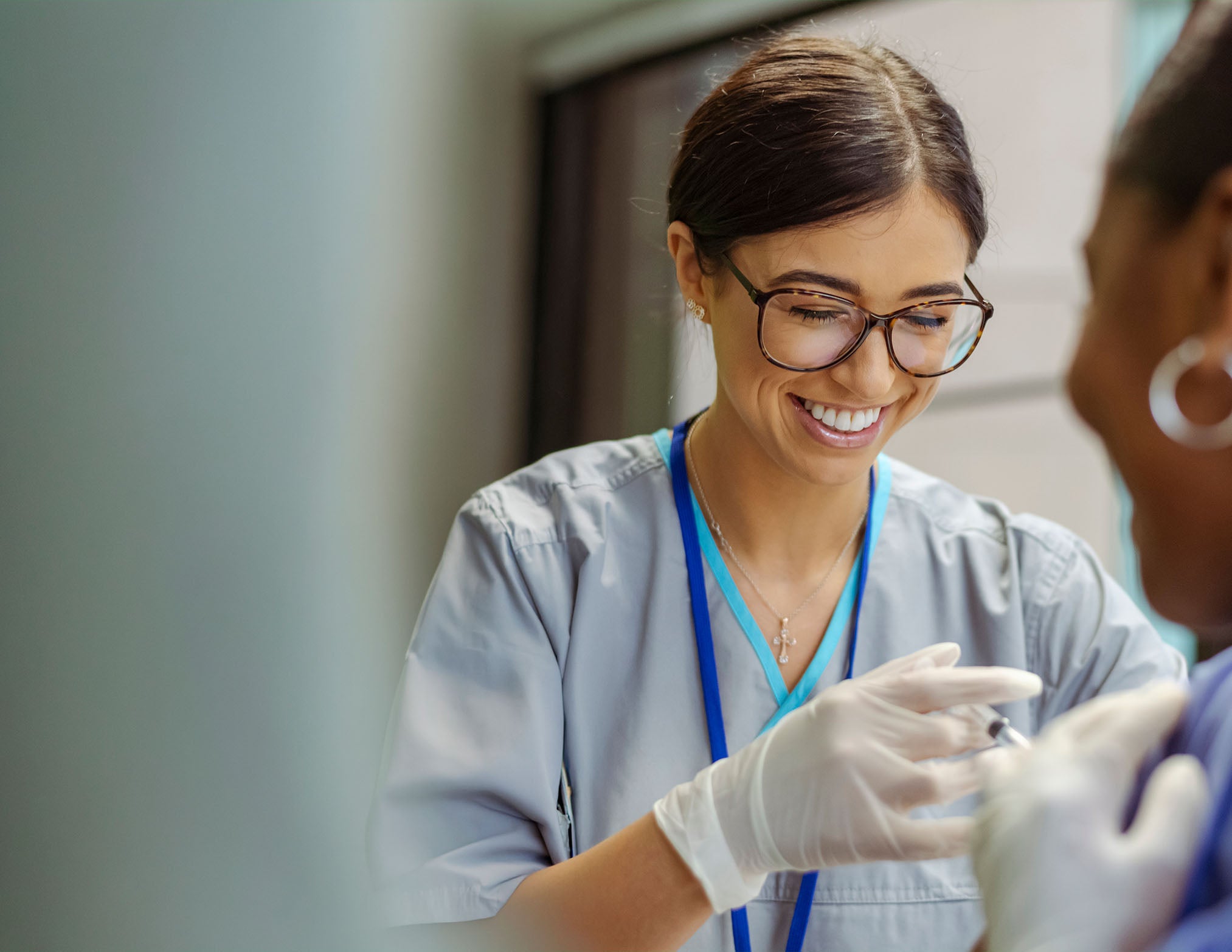 1. A smiling female nurse gently holds a patient's hand, conveying care and compassion in a healthcare setting.
