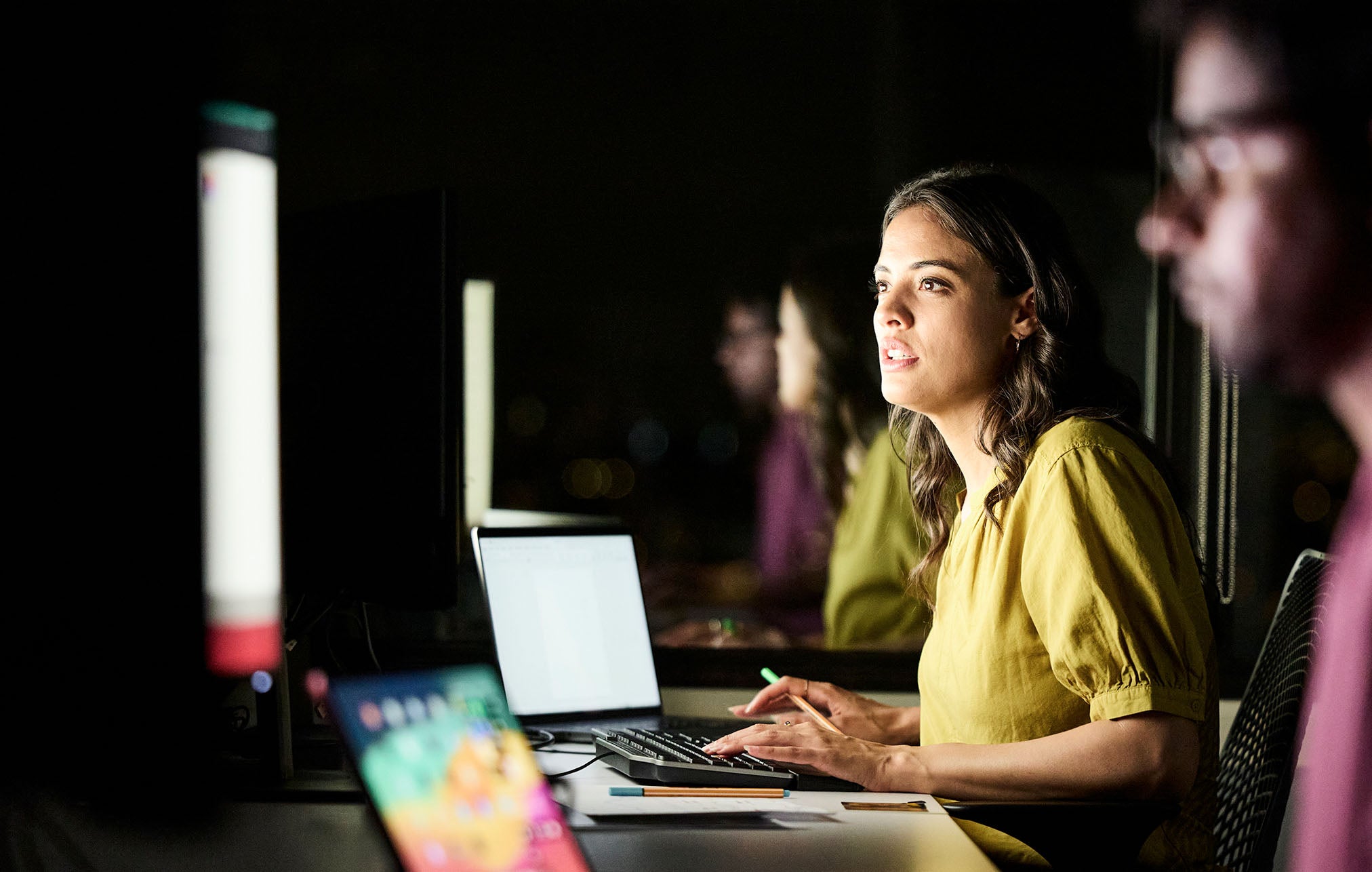 1. A woman gazes intently at a computer screen, focused on her work or research.