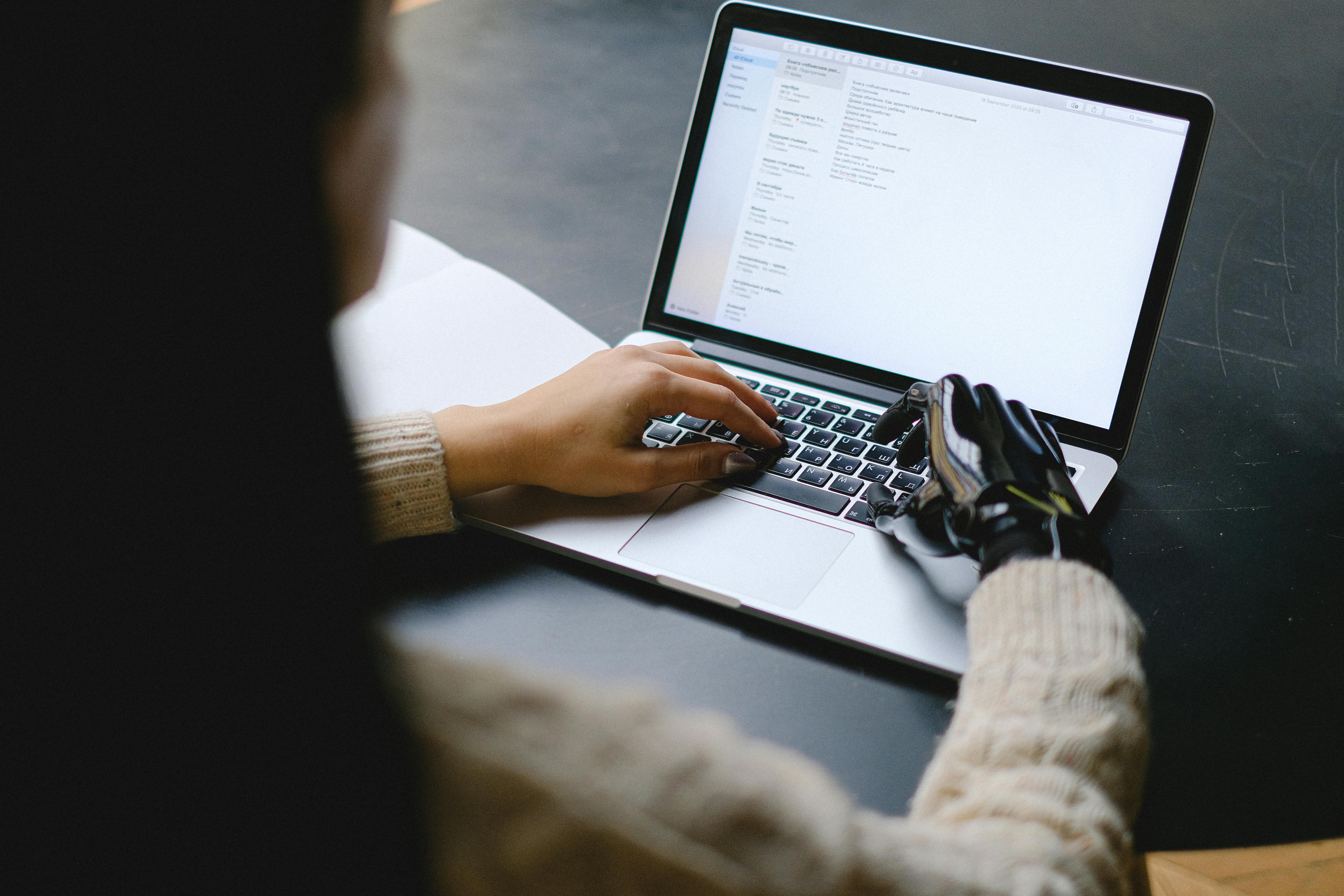 A Woman Using a Laptop With A Robotic Hand
