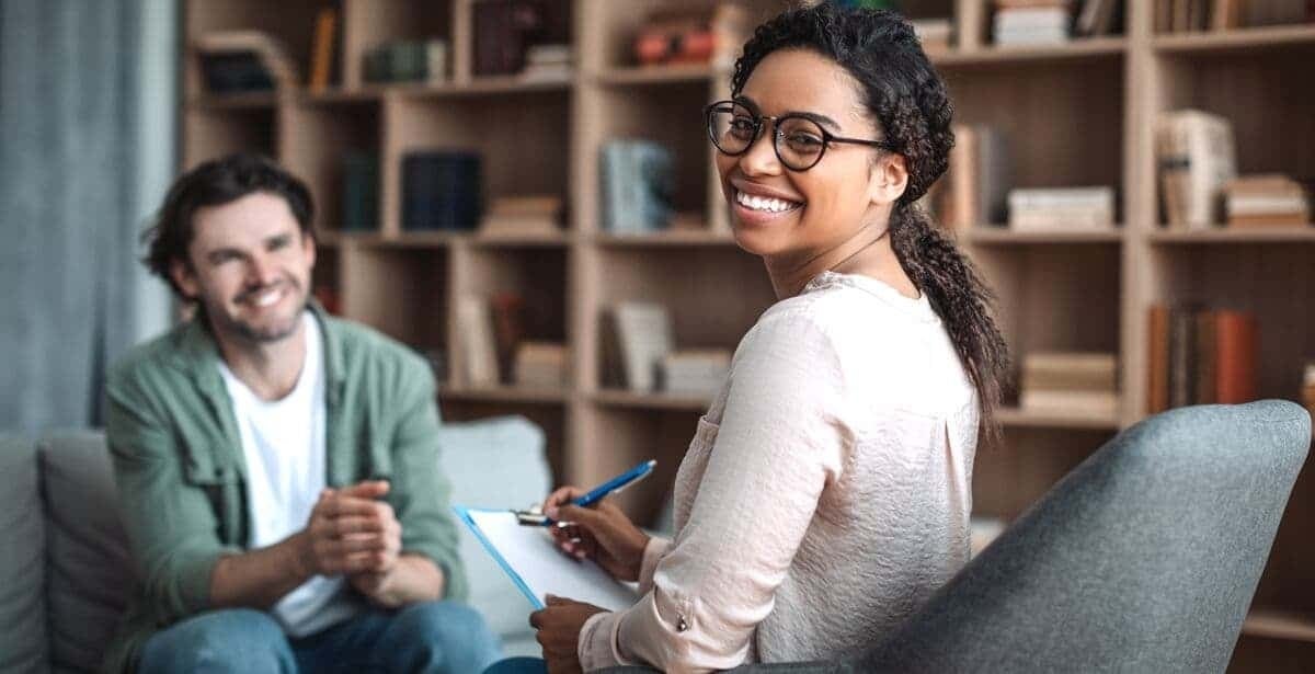 A psychologist and their patient smiling together.