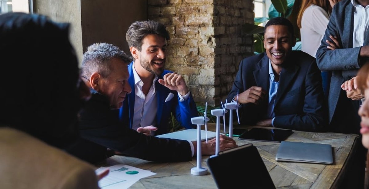 A diverse group of professionals collaborating on a sustainability initiative in an office setting.