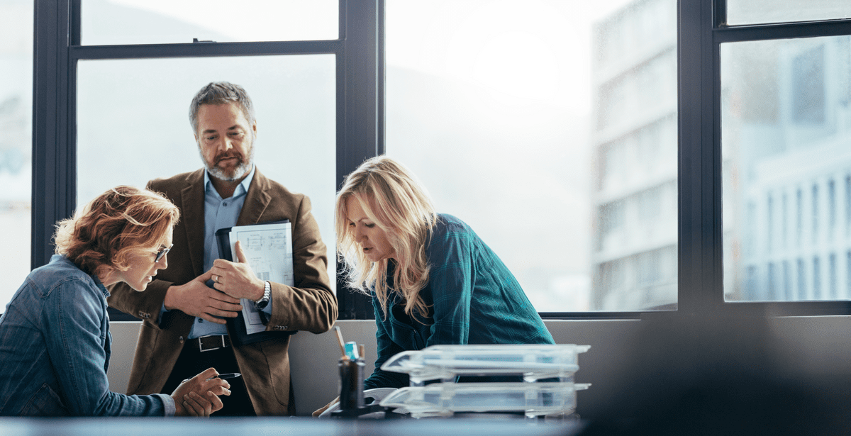 business meeting between four colleagues discussing technology management 