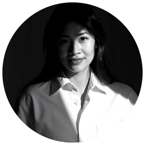 A woman in a white shirt poses for a photo, smiling and looking directly at the camera.