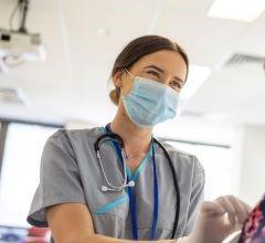 A nurse wearing a mask and gloves is giving an injection to a patient in a healthcare environment.
