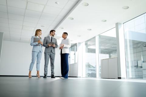 Three property valuers standing in an empty building, discussing property valuation.