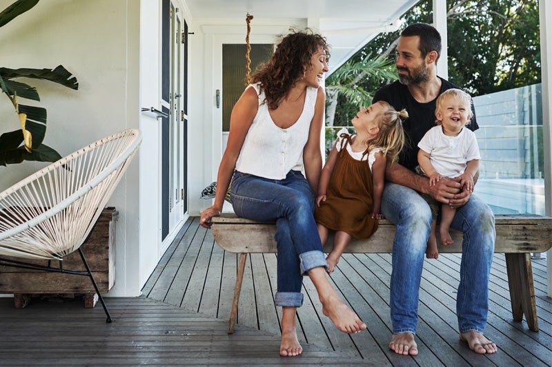 A family relaxes on a porch, enjoying a sunny day together.